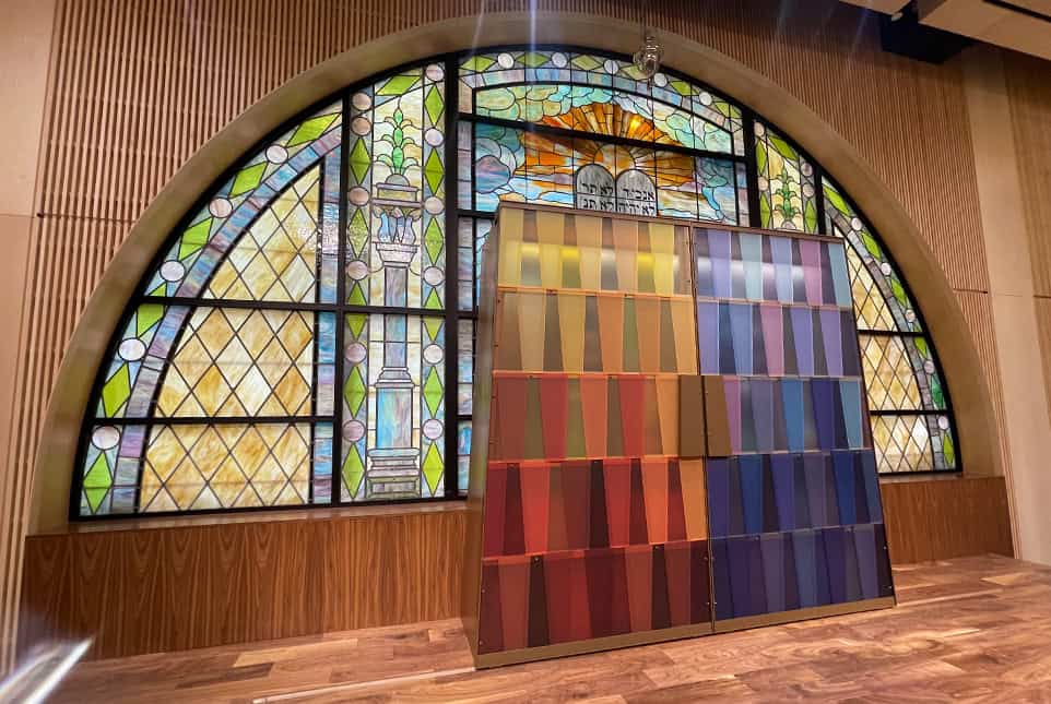 Congregation Shaare Zedek 1 Colorful stained glass window with fabric samples display in front.