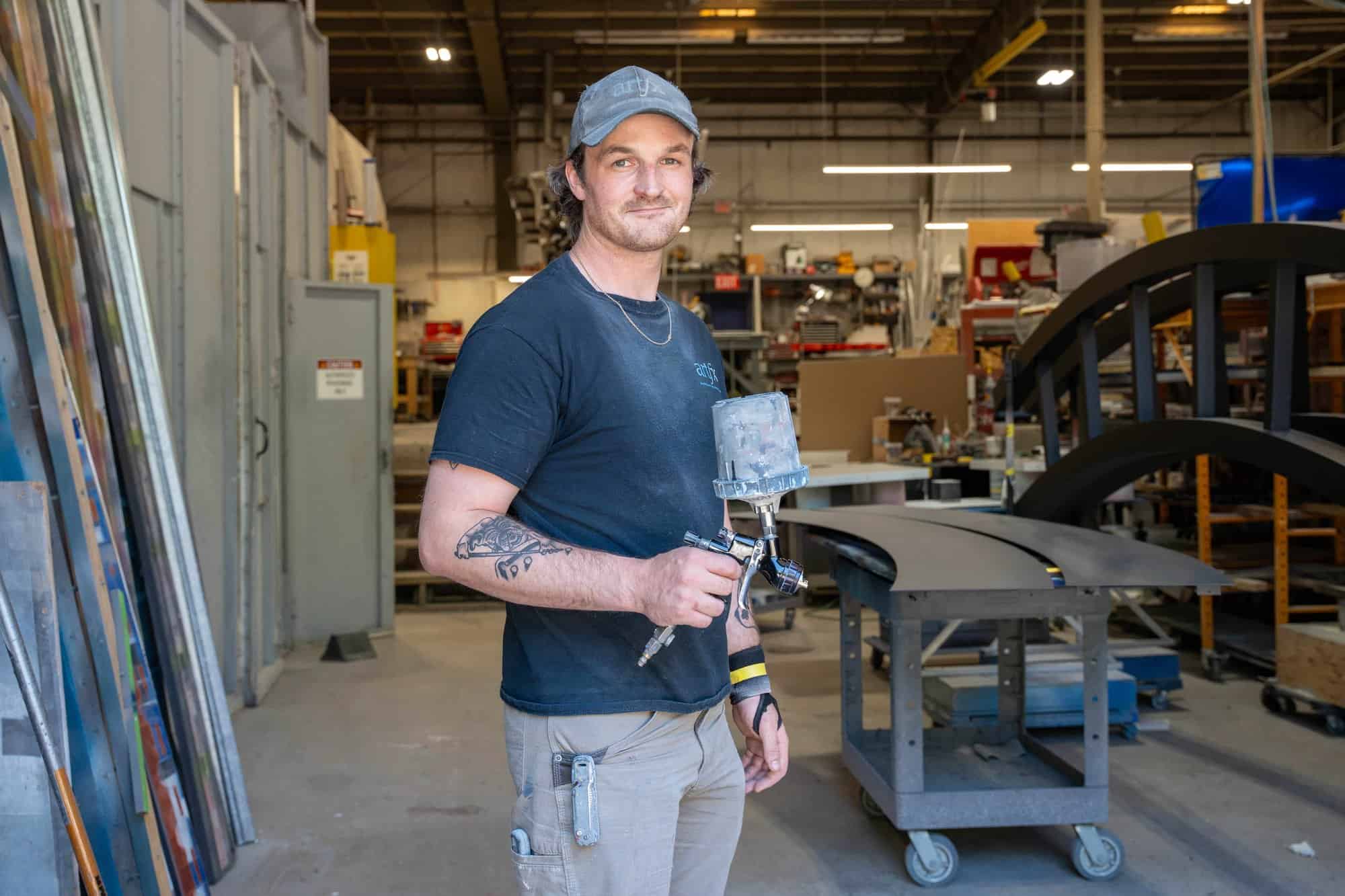 ARTfx industrial spray painter holding a paint gun in the Bloomfield, Connecticut fabrication shop